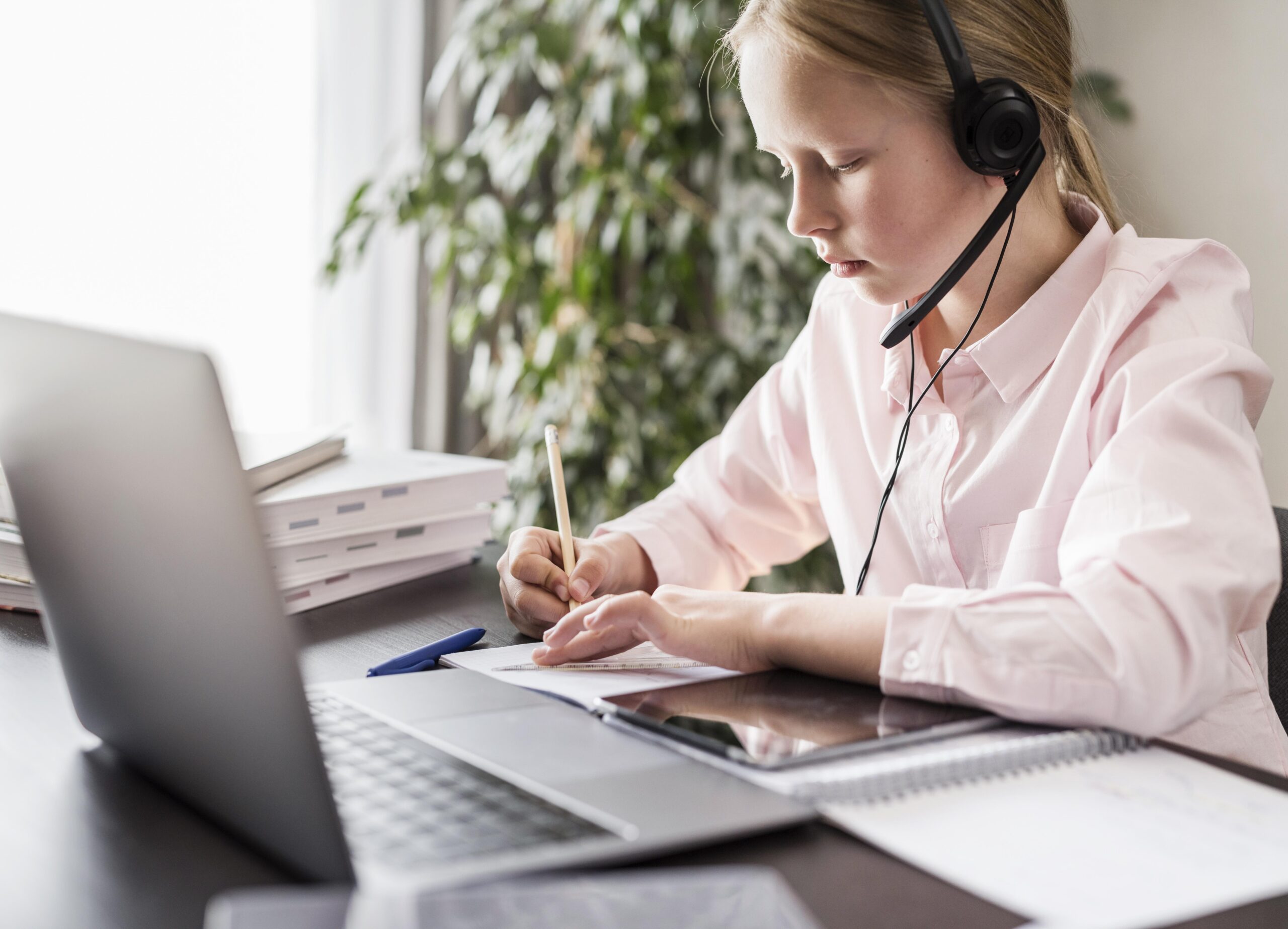 girl participating online class while writing